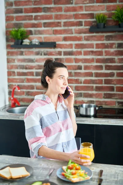 Žena hovoří telefonicky u snídaně — Stock fotografie