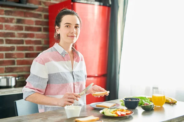 Mujer joven preparando el desayuno — Foto de Stock