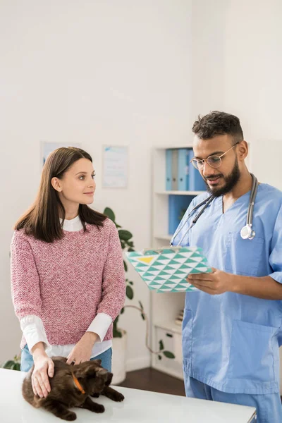 Joven Veterinario Médico Haciendo Recetas Para Gato Enfermo Mientras Habla — Foto de Stock