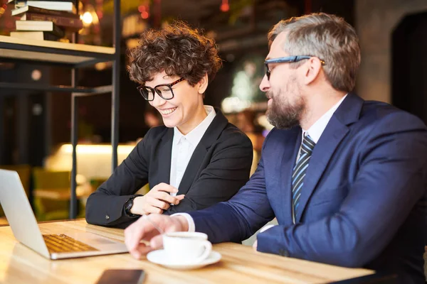 Ung Affärskvinna Tittar Laptop Skärm Samtidigt Som Interagerar Med Kollega — Stockfoto