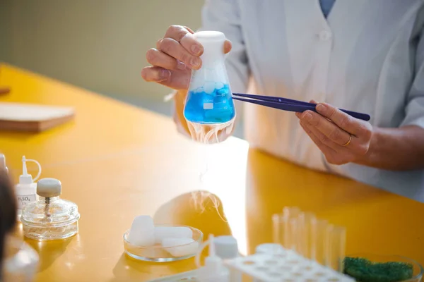 Young Female Researcher Whitecoat Holding Tweezers Beaker Fuming Fluid Table — Stock Photo, Image