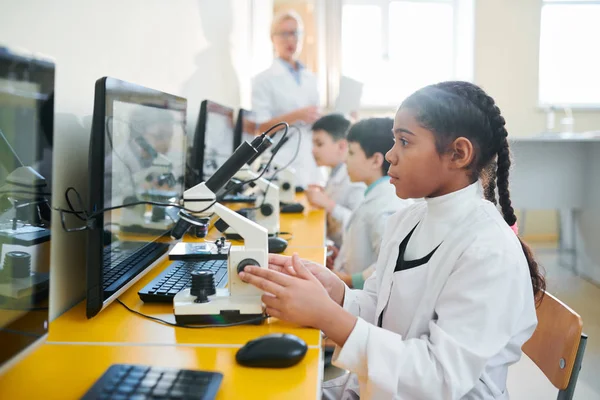 Rad Små Skolbarn Whitecoats Sitter Klassrummet Längs Skrivbordet Och Studerar — Stockfoto