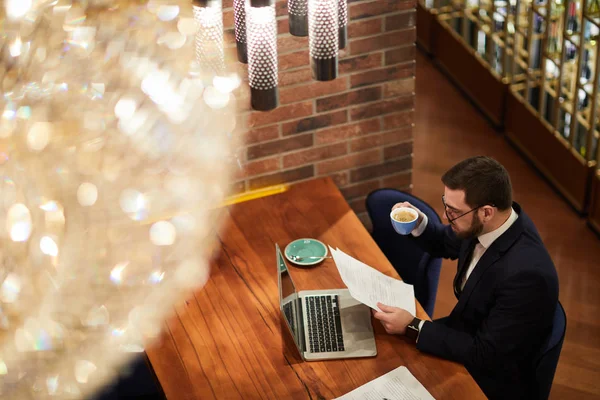 Comerciante Ocupado Diretor Sentado Restaurante Lendo Papéis Financeiros Frente Laptop — Fotografia de Stock