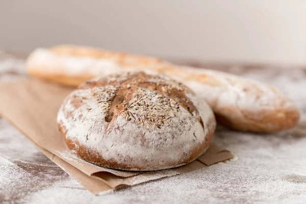 Świeżo Upieczony Domowy Chleb Żytni Opakowaniu Papierowym Bagietką Pszenną Tle — Zdjęcie stockowe