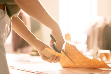 Masaya göre kağıt desenleri üzerinde çalışan ve onları kesme makas ile genç kadın terzi