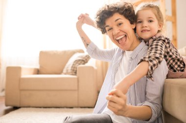 Hafta sonu evde zaman harcama sırasında sevimli küçük kızı ile oynayan Ecstatic Genç Anne