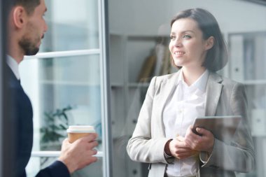 Ofiste çalışma noktaları nın tartışılması sırasında meslektaşının önünde duran dokunmatik yüzeyli kendine güvenen genç kadın yönetici