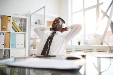 İşyeri tarafından mola keyfi sırasında kulaklıkta müzik dinlerken harika insanlar genç rahat işadamı
