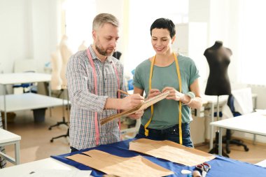 İki profesyonel moda tasarımcıları, yeni taslaklar yapma ve tartışmak için giyim içinde terzilik Dükkanı