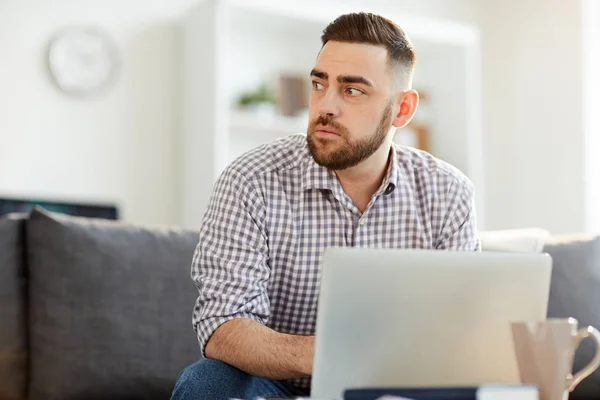 Young Serious Man Casualwear Looking Aside While Sitting Sofa Front — Stock Photo, Image