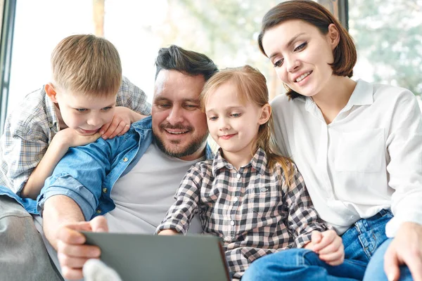 Happy Young Contemporary Family Four Looking Touchpad Display While Watching — Stock Photo, Image