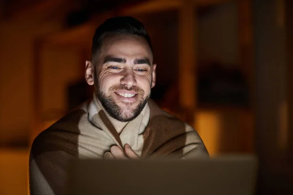 Счастливый Молодой Человек Завернутый Клетку Сидит Перед Ноутбуком Темной Комнате — стоковое фото