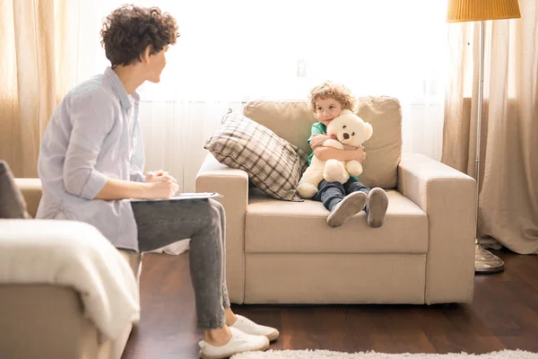 Schattige Kleine Jongen Met Witte Teddy Zitten Fauteuil Terwijl Bespreking — Stockfoto