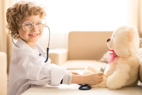 可爱快乐的小男孩在白教堂和眼镜看着你 而扮演医生与泰迪熊 — 图库照片