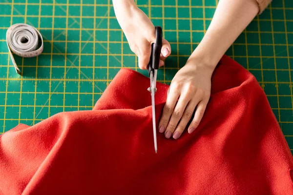 Manos Humanas Sosteniendo Tijeras Textiles Rojos Mientras Corta Tablero Verde — Foto de Stock