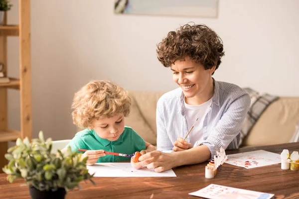 Mujer Bonita Sosteniendo Huevo Pascua Sobre Papel Mientras Pequeño Hijo —  Fotos de Stock