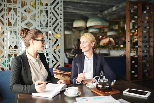 Dos Jóvenes Elegantes Compañeras Sentadas Mesa Cafetería Planeando Trabajo Tomando — Foto de Stock