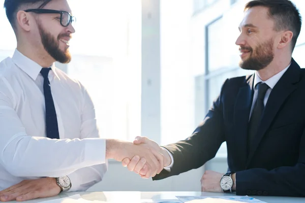 Två Unga Framgångsrika Affärspartners Skakar Hand Över Arbetsplatsen Och Tittar — Stockfoto