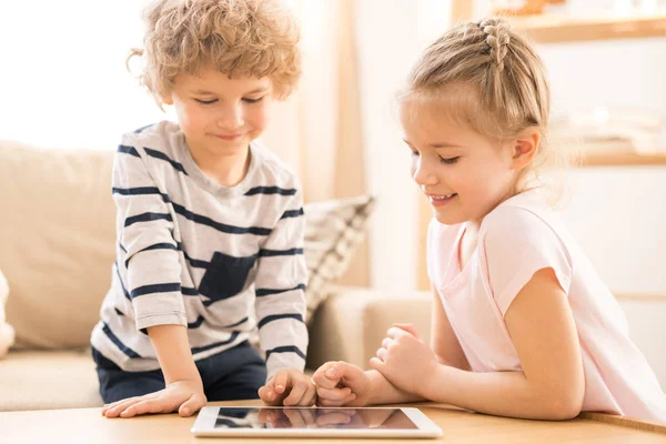 Küçük Kardeşler Masa Üzerinde Tablet Üzerinde Bükme Sırasında Ebeveynler Dışarı — Stok fotoğraf