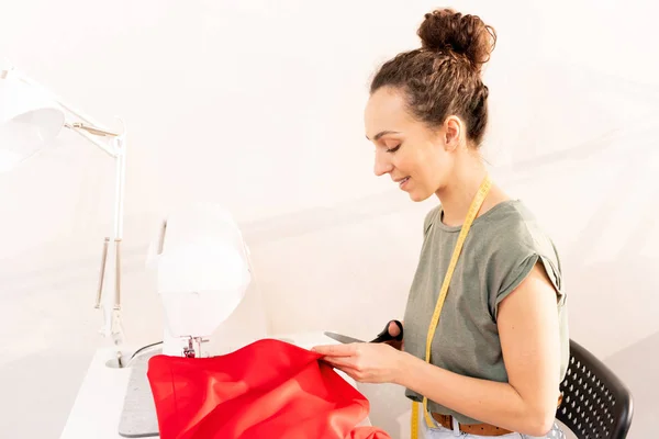 Jonge Vrouw Met Schaar Snijden Rood Textiel Zittend Door Naaimachine — Stockfoto