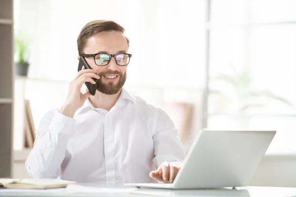 Young Confident Agent Broker Consulting Client Smartphone While Looking Laptop — Stock Photo, Image