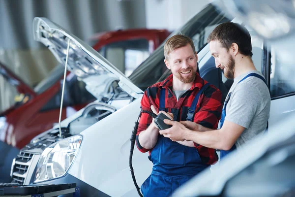 Feliz Joven Barbudo Reparador Ropa Trabajo Explicando Colega Cómo Utilizar — Foto de Stock