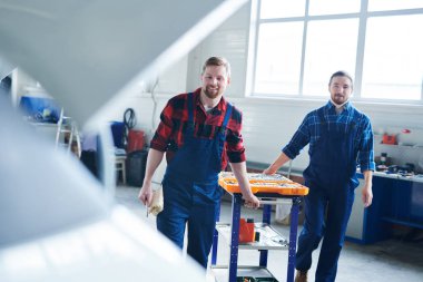 Endüstriyel makine tamir giderken açık araç seti ile tezgah çekerek tulum iki genç mühendis