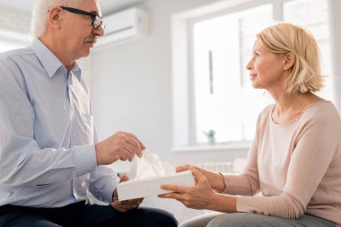 Oturum sırasında üst düzey bir adam sunarken kağıt dokuları ile Sarışın olgun kadın tutma kutusu