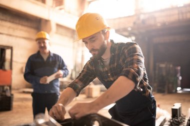 Çağdaş makine builsing tesisi kontrol veya atölyede yeni ekipman test sakallı işçi