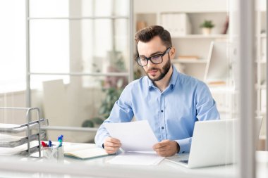 Anlaşma için kağıthazırlarken masa başı finansal belgeleri okurken akıllı gündelik okumada ciddi finansör