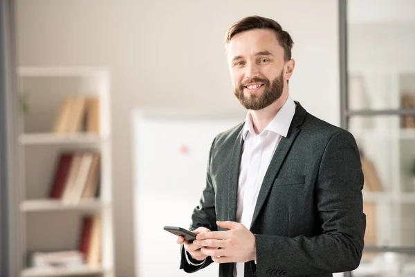 Joyeux Jeune Gestionnaire Souriant Agent Avec Smartphone Debout Devant Caméra — Photo