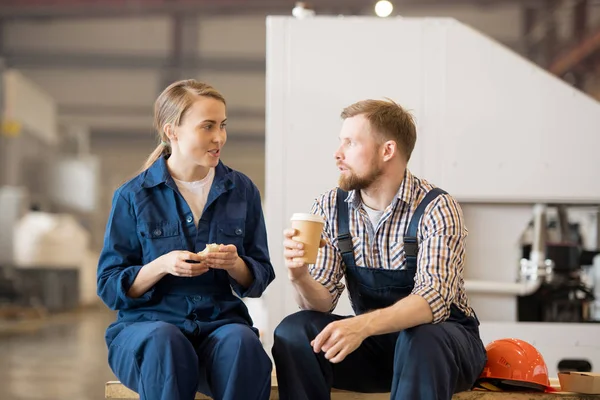 Jonge Man Vrouw Werkkleding Zittend Werkplaats Terwijl Eten Drinken Pauze — Stockfoto
