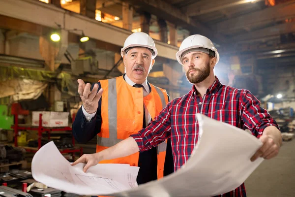 Dois Construtores Máquinas Confiantes Uniformes Chapéus Duros Discutindo Detalhes Técnicos — Fotografia de Stock