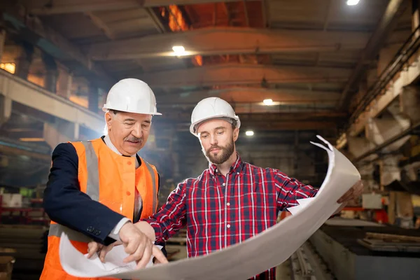 Senior Foreman Hardhat Uniformen Ongevouwen Blauwdruk Terwijl Hij Zijn Ondergeschikte — Stockfoto