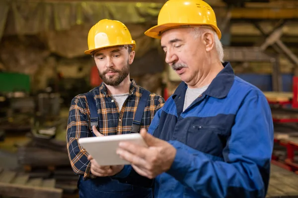 Dos Ingenieros Profesionales Cascos Ropa Trabajo Mirando Pantalla Tableta Mientras —  Fotos de Stock