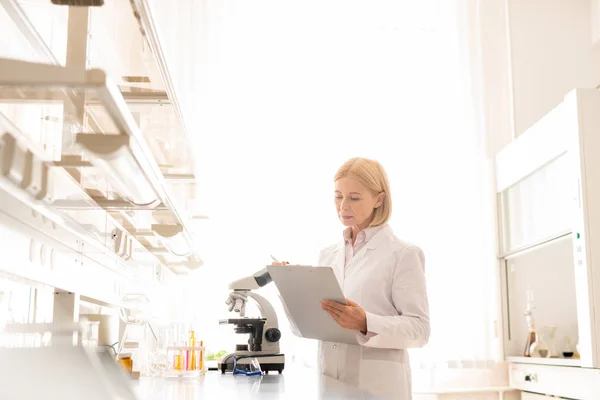 Allvarliga Upptagen Mogen Kvinnlig Vetenskapsman Lab Coat Stående Laboratorie Rummet — Stockfoto