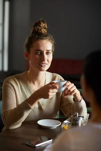 Çay Veya Kahve Fincan Ile Mutlu Genç Kadın Arkadaşının Önünde — Stok fotoğraf