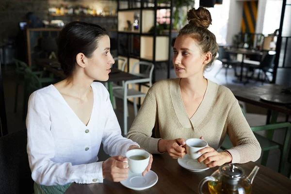 Duas Mulheres Muito Jovens Casualwear Sentado Café Acolhedor Tendo Chá — Fotografia de Stock