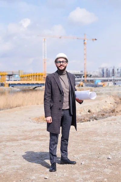 Щасливий Молодий Архітектор Костюмі Шубці Хардхаті Стоїть Землі Місці Будівництва — стокове фото
