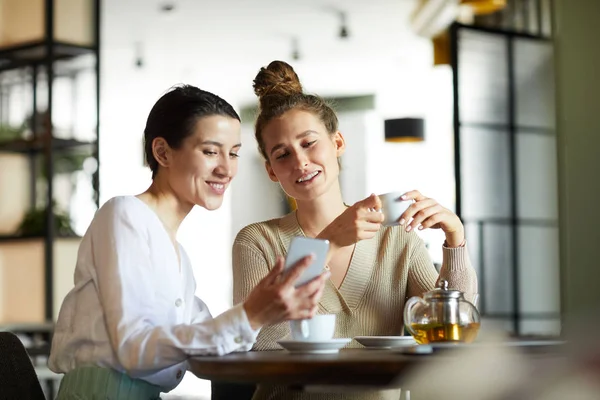 Due Giovani Donne Casualwear Guardando Video Curioso Nello Smartphone Mentre — Foto Stock