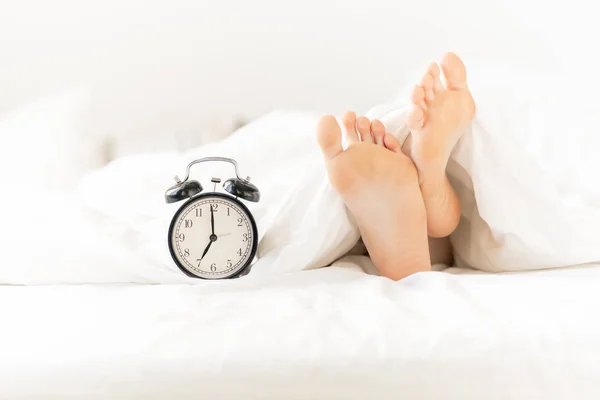 Alarm Clock Bed Next Bare Female Feet Soles Stuck Out — Stock Photo, Image