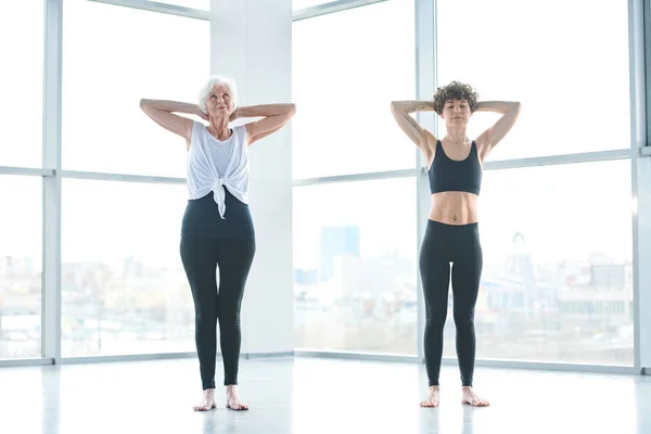 Two Active Contemporary Women Keeping Hands Backheads While Doing One — Stock Photo, Image