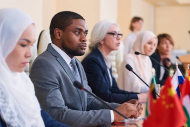 Genç ciddi Afro-Amerikan işadamı, konferans katılımcısı, dikkatle konuşmacılardan biri rapor dinleme