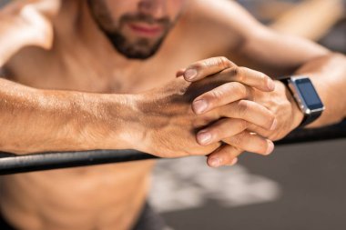 Egzersiz veya dinlenme sırasında spor çubuğu üzerinde genç gömleksiz atlet Eller açık havada eğitim den sonra