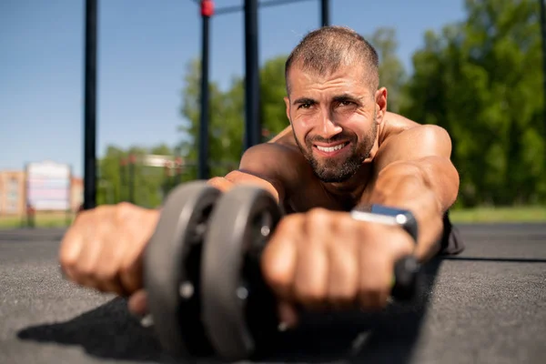 Jonge Bodybuilder Met Sportspullen Rollen Voorwaarts Terwijl Het Houden Van — Stockfoto