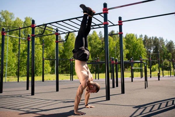 Atractivo Joven Atleta Muscular Haciendo Handstand Terreno Deportivo Día Soleado — Foto de Stock