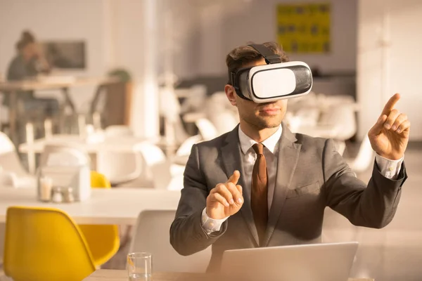 Young employee in formalwear touching virtual screen while explaining data during vr presentation in cafe or restaurant