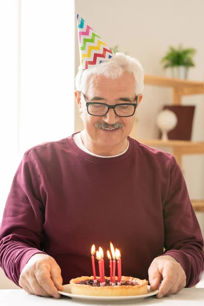 Glücklicher Senior Macht Geburtstagswunsch Beim Anblick Brennender Kerzen Auf Selbstgebackenem — Stockfoto