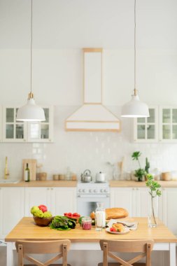 Mutfak ve sebze ve ev yapımı gıda ile masa üzerinde asılı lambalar ile modern düz veya evde mutfak iç