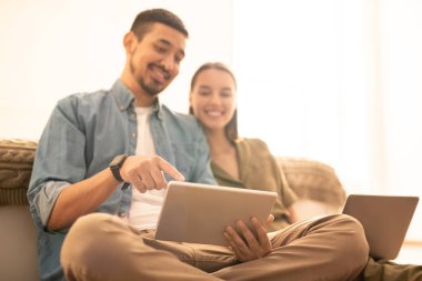 Kaydırma ve boş zamanlarında eşi meraklı anlar veya online video gösterirken tablet ekran işaret genç adam